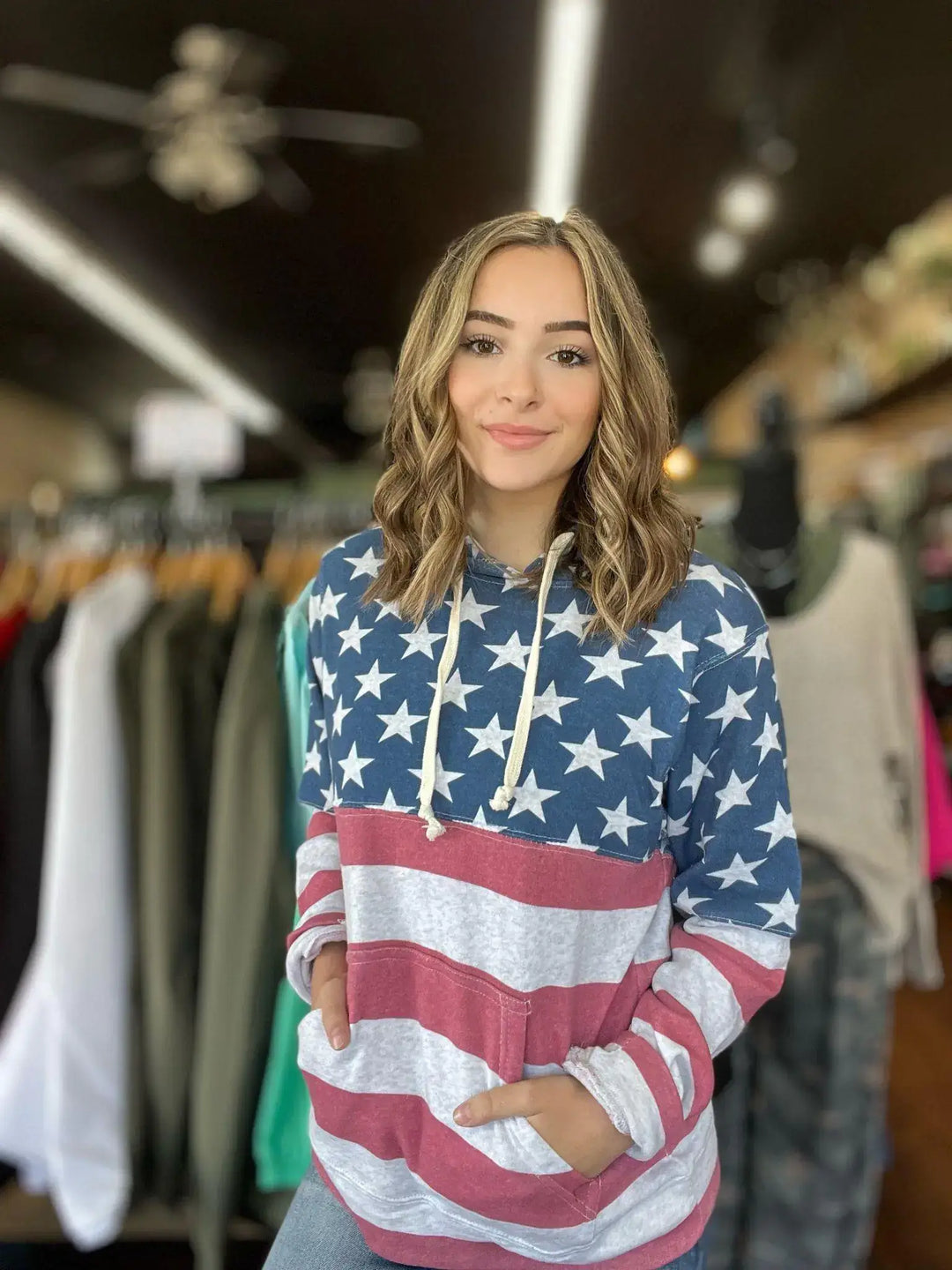 American Flag Hoodie This hoodie is perfect for the whole family! Super soft with pockets, completely wrapped in the American Flag! Perfect year round! Model is wearing size Small, her true size. $55.0 to $55.0