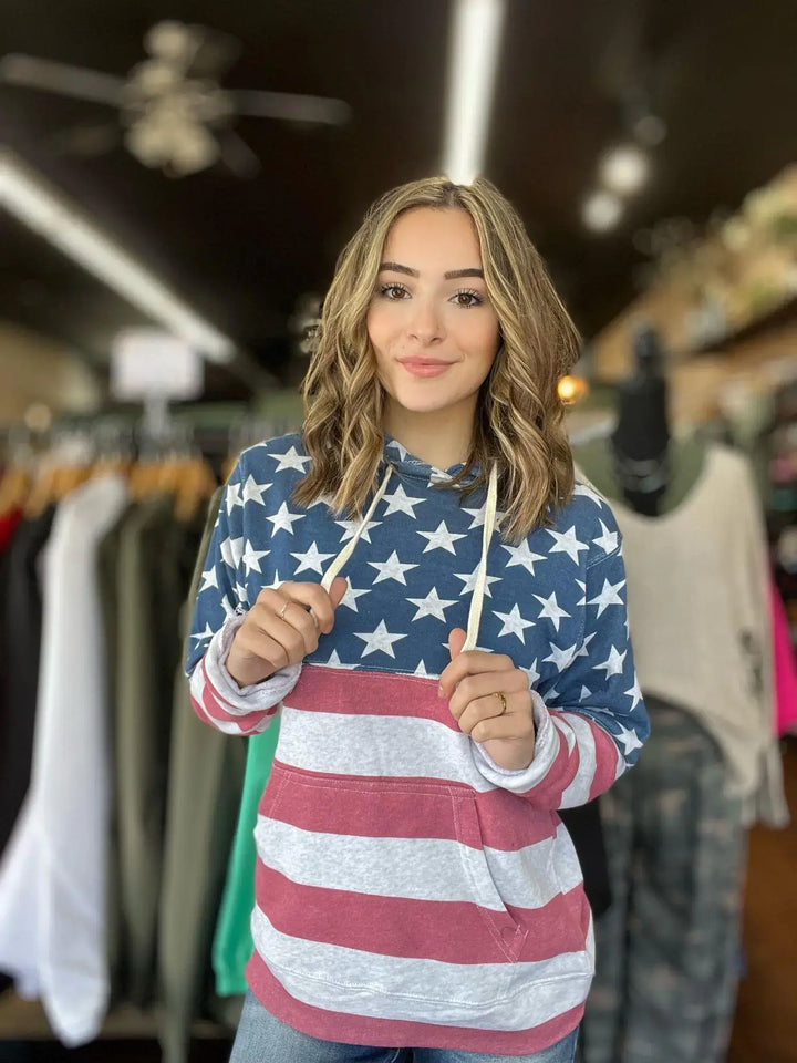 American Flag Hoodie This hoodie is perfect for the whole family! Super soft with pockets, completely wrapped in the American Flag! Perfect year round! Model is wearing size Small, her true size. $55.0 to $55.0